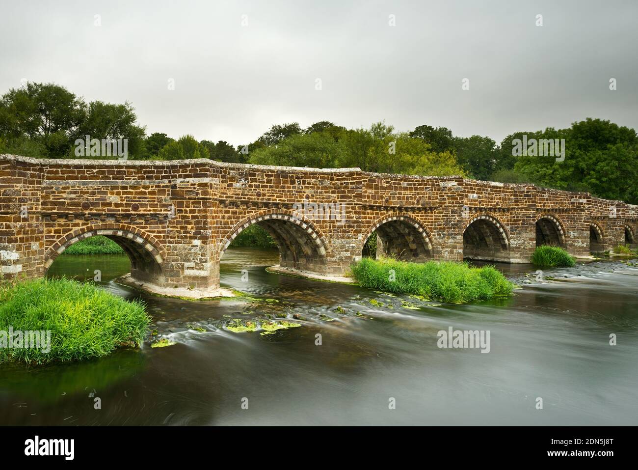 A summertime picture of the eight arched, Medieval, White Mill bridge over the River Stour near Sturminster Marshall in Dorset, England, UK Stock Photo