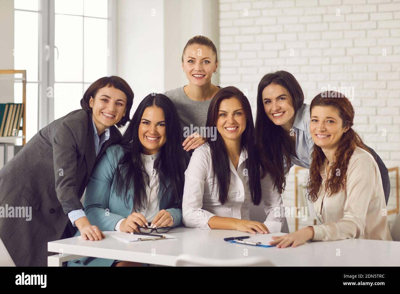 Smiling businesswomen looking at camera during brainstorming in office Stock Photo