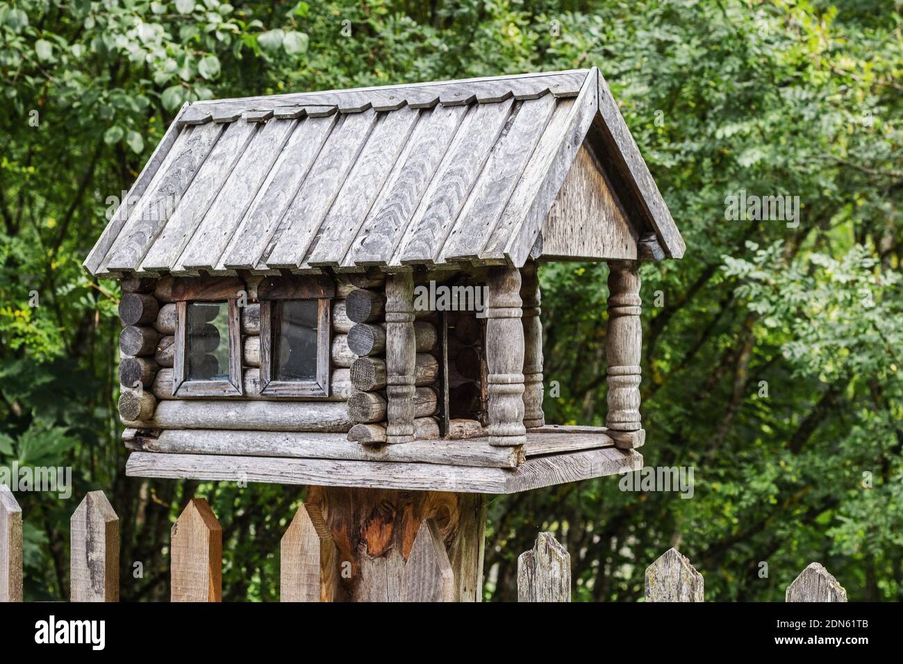 Bird feeder made of wood in the form of a house with a porch Stock