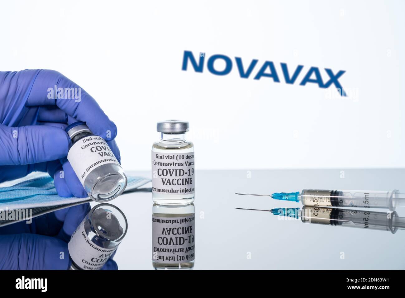 Morgantown, WV - 16 December 2020: Small bottle of coronavirus vaccine with syringe with background of Novavax logo Stock Photo