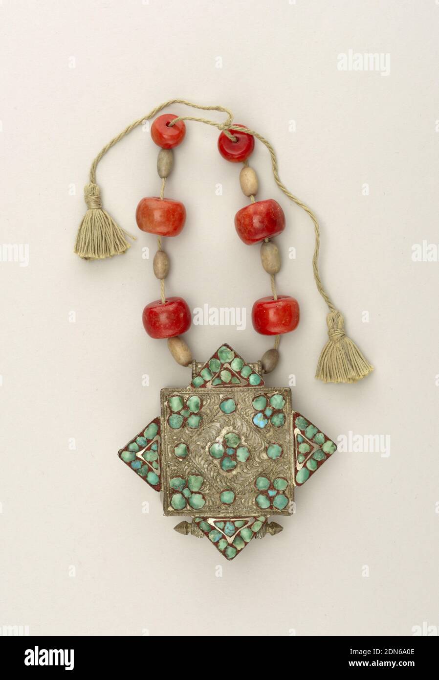 Necklace with amulet, Silver alloy, turquoise, carnelian beads, fiber, Amulet: metal, probably silver alloy. Box 5.5 cm (2 1/8 in.) square, with cover having filigree and turquoise ornamentation including four triangular pieces at base, applied at each side of cover making overall dimension of cover an approximate square 6.5 cm. Hollow cylinders permit a cord with twelve beads (cord supplemented by neck ribbon) to suspend amulet from neck. Purpose of other cylinder, ornamented with twisted wire and conical ends, probably purely decorative., 19th century, jewelry, Decorative Arts, Necklace Stock Photo
