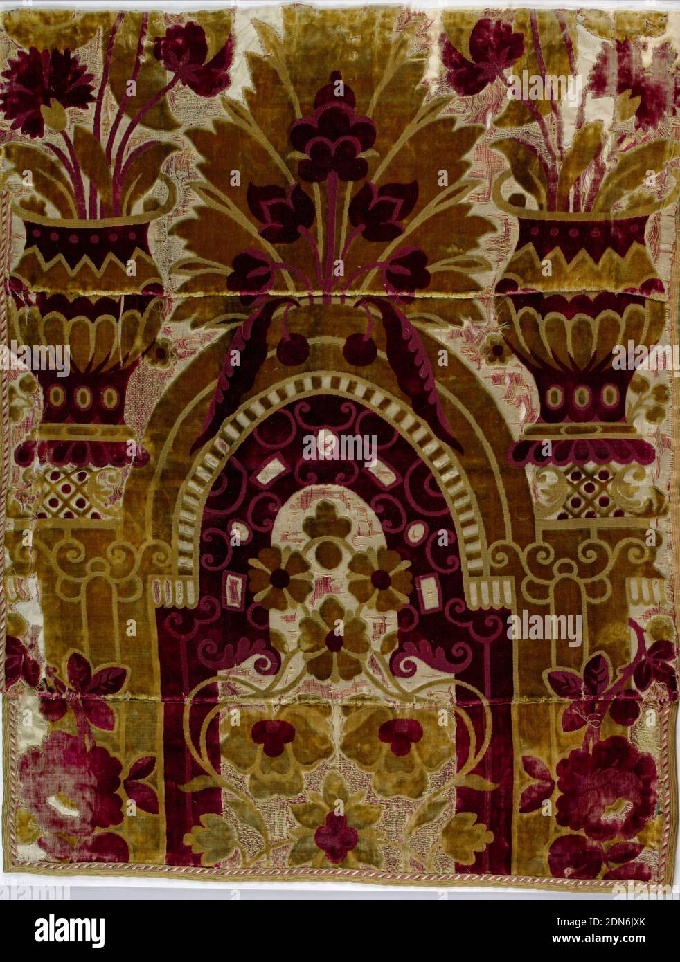 Fragment, Medium: silk Technique: cut and uncut velvet with satin ground, This fragment preserves only a section of a much larger pattern. The design is in olive green and deep red cut and uncut velvet on cream satin ground. The upper portion of an arch, its supporting pillars, and large vase forms and large scale floral above the arch. This piece sewn together with 1948-116-2-a,b. Right selvedge present., probably Spitalfields, England, 1700–1710, woven textiles, Fragment Stock Photo
