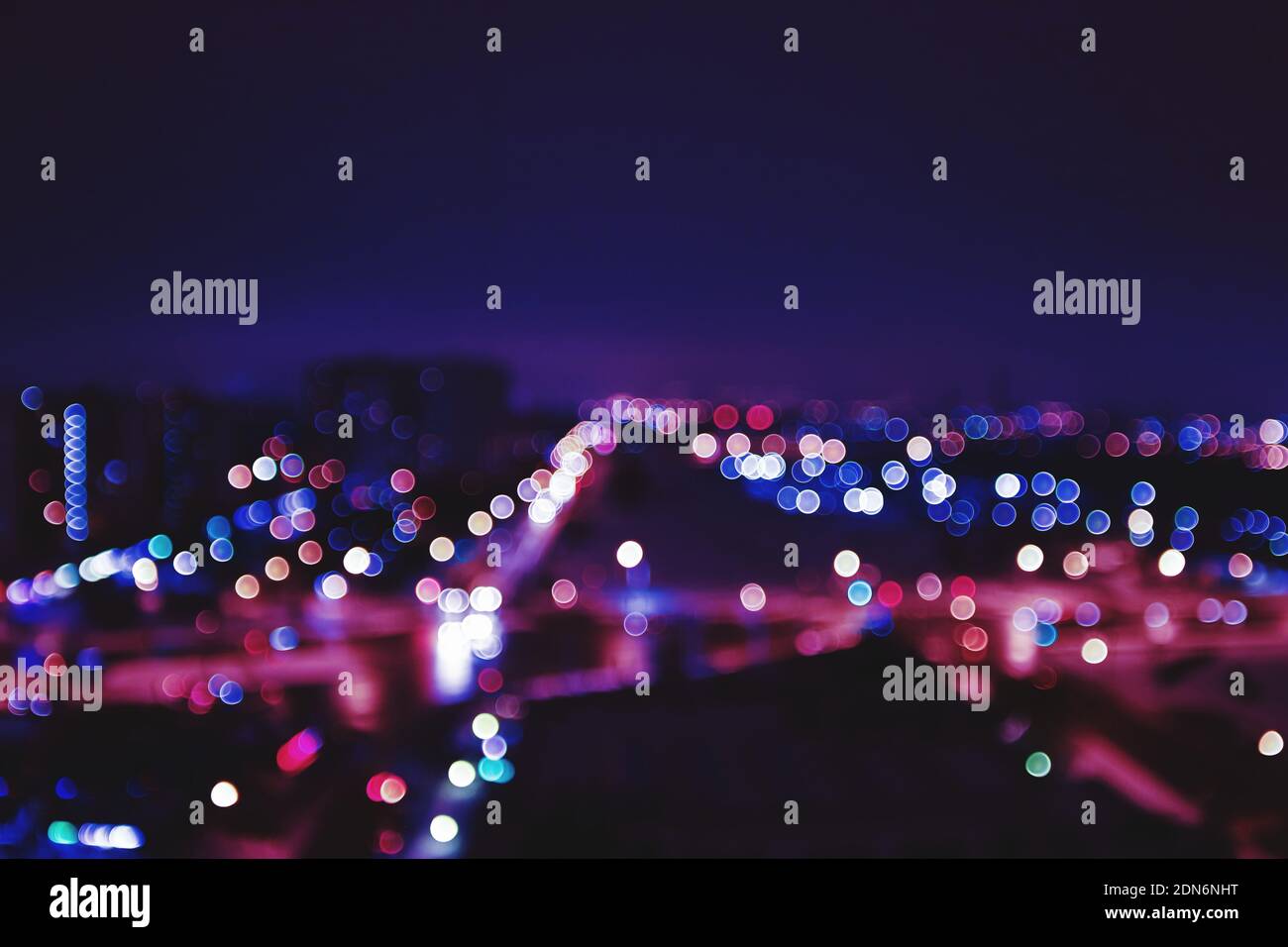 Defocused Image Of Illuminated City Against Sky At Night Stock Photo