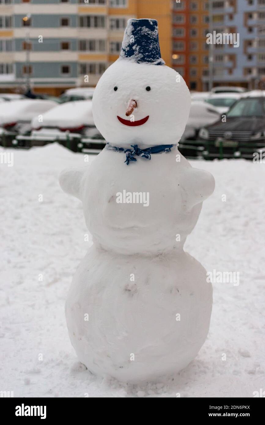Snowman in the yard with a bucket on his head Stock Photo - Alamy