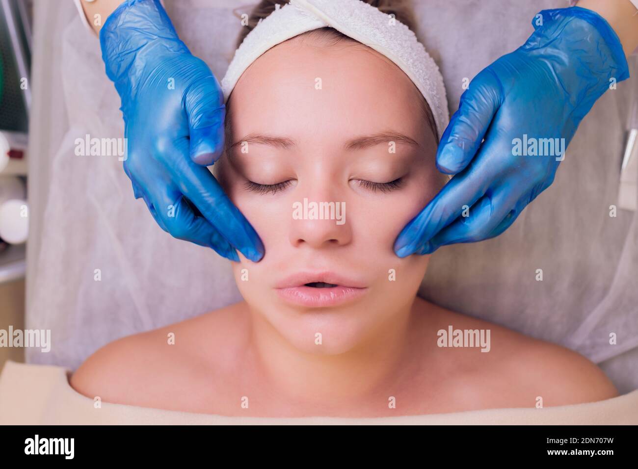 Top view of beautiful young woman getting face skin treatment