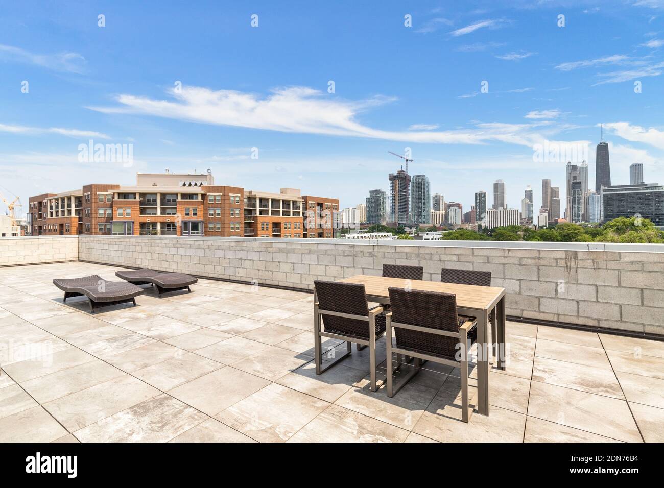 A rooftop patio of a Chicago condo building with a view of the skyline