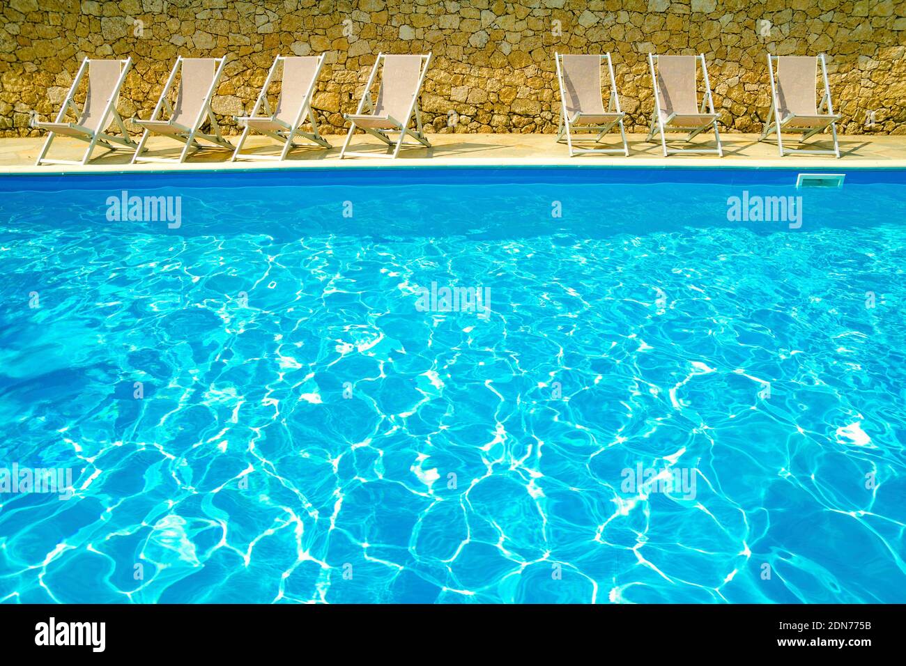 pool with chaiselongues in hotel Stock Photo Alamy