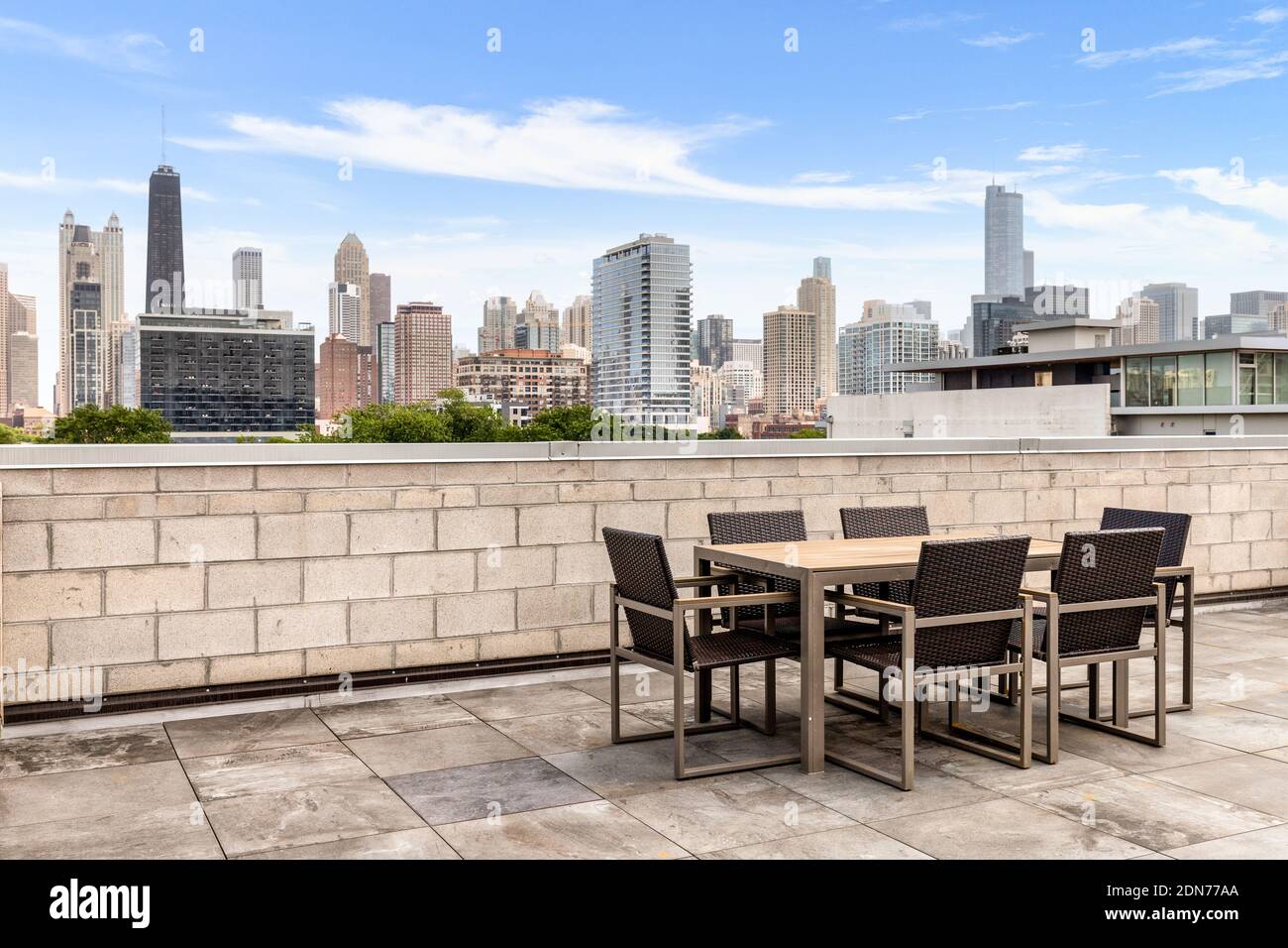 A rooftop patio of a Chicago condo building with a view of the skyline