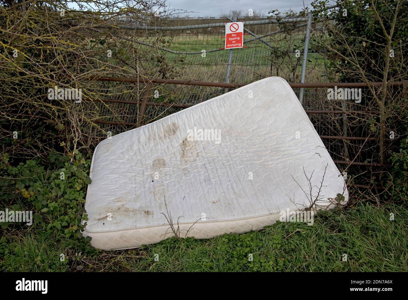 Old mattress dumped by  litter signs in rural Warwickshire UK Stock Photo