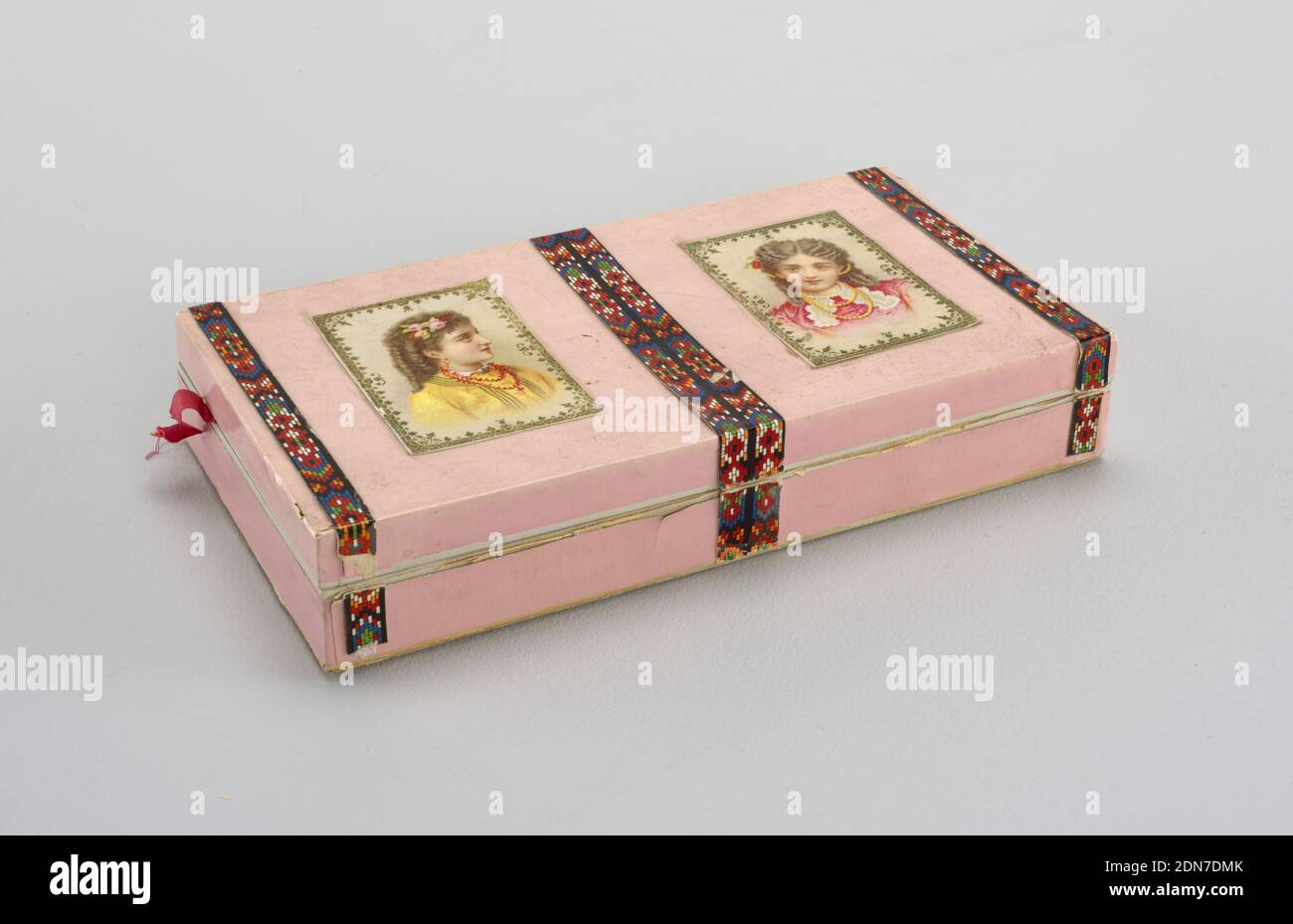 Box and cover, Cardboard and paper, Rectangular box and cover (formerly paper-hinged) covered with glossy pink paper and with strips of multicolored paper framing two colored lithograph prints of young girls on the cover. Inside edged with lace paper., USA, 1880–90, Decorative Arts, Box and cover Stock Photo