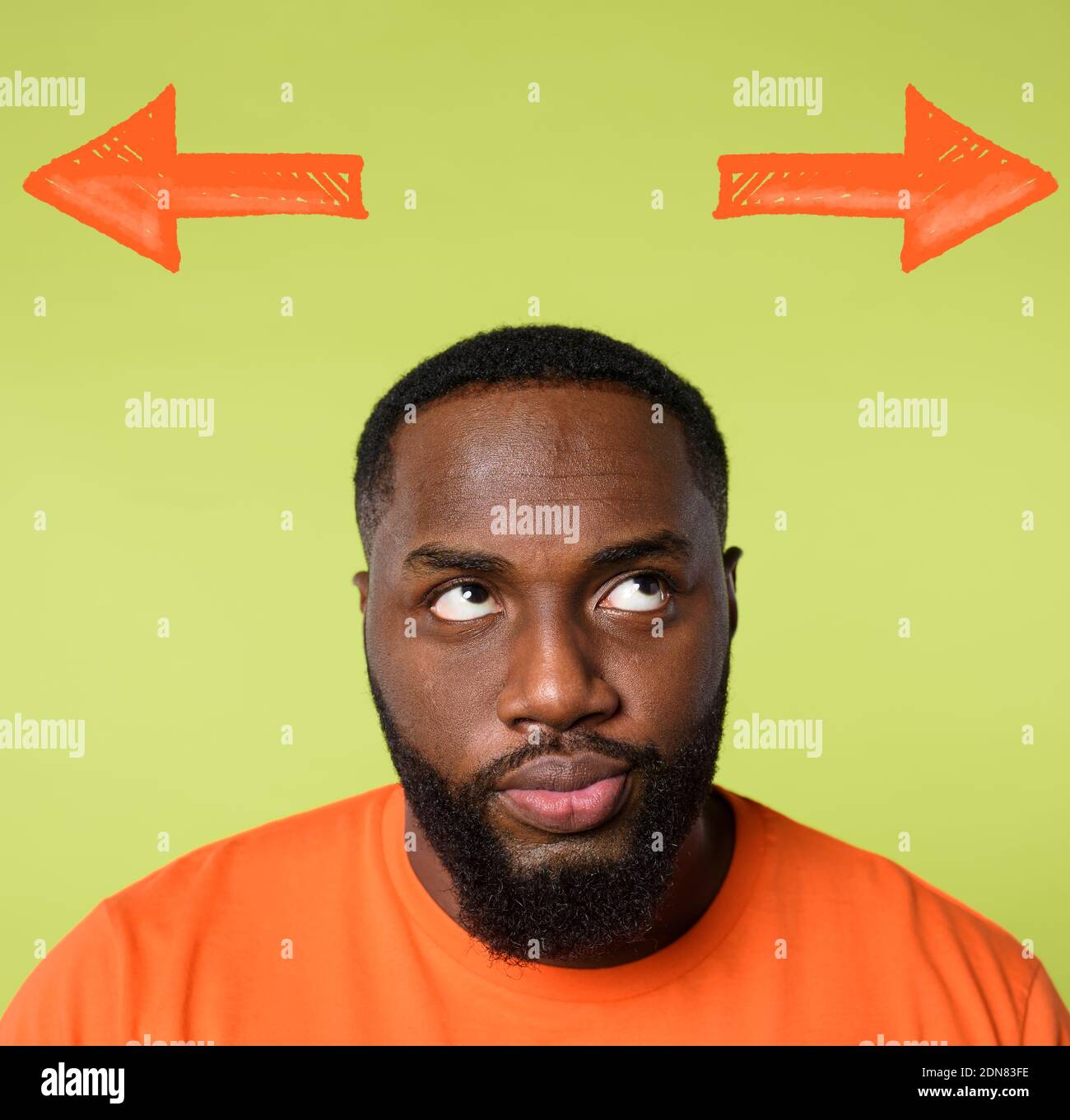 Confused black Man has to choose the right arrow to follow. Concept of options, confusion, decision. Stock Photo