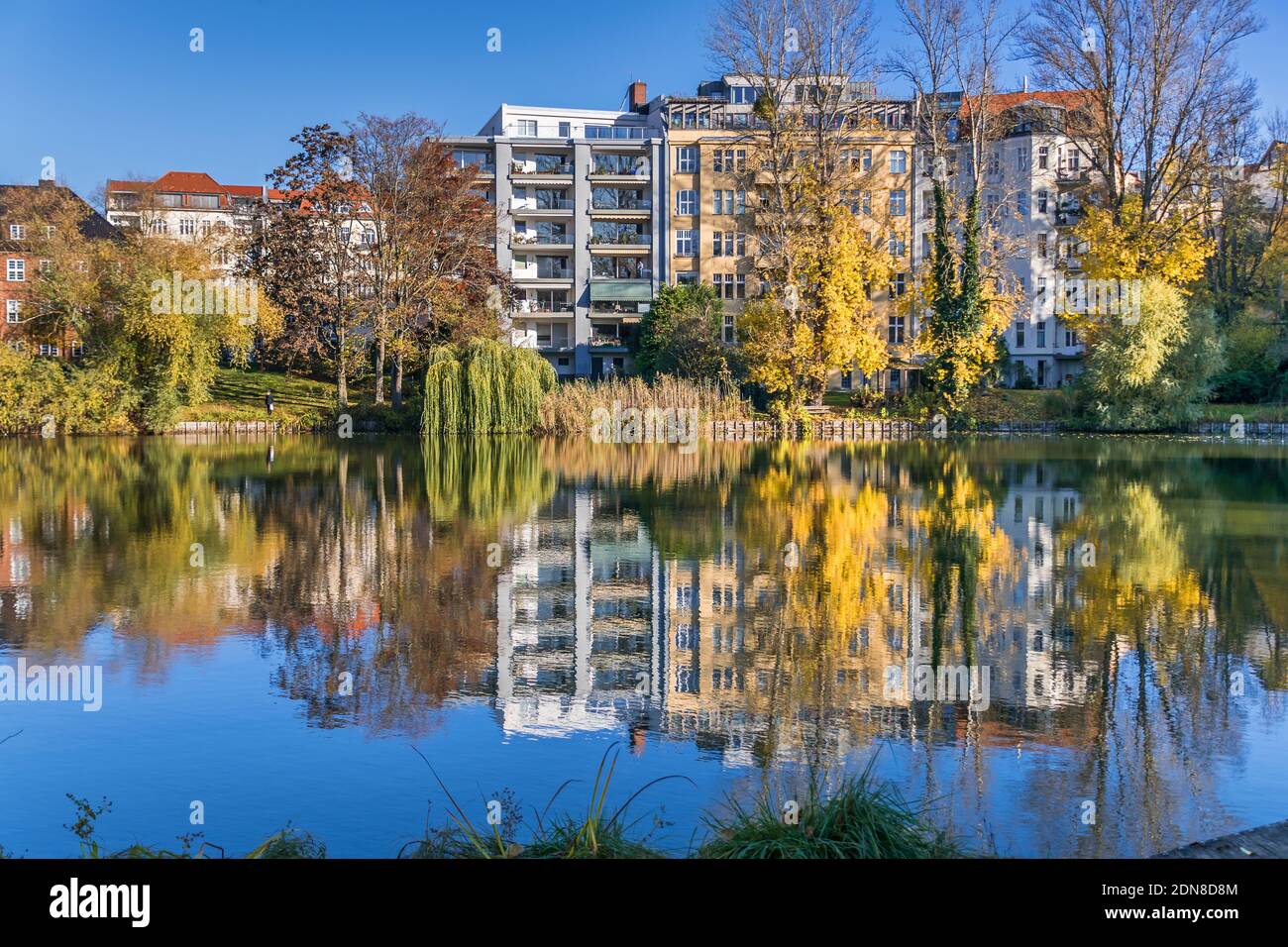 Berlin, Germany - November 7, 2020: Park and a listed garden Lietzensee and buildings on the shore of Lake Lietzen with its facades reflecting in the Stock Photo