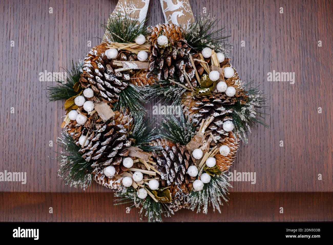 December 2020 - Milan: Christmas wreath hanging on a wooden door Stock Photo