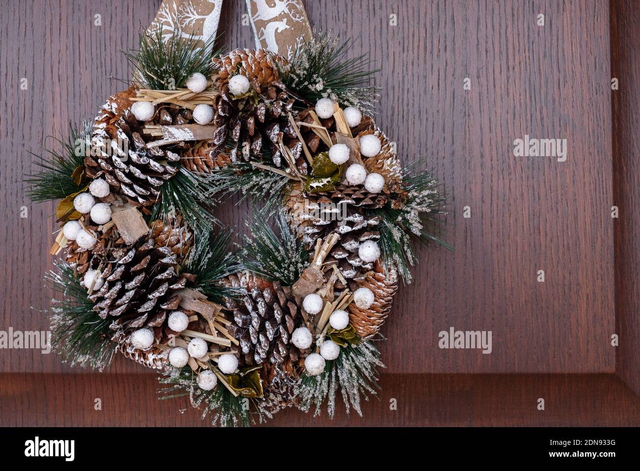 December 2020 - Milan: Christmas wreath hanging on a wooden door Stock Photo