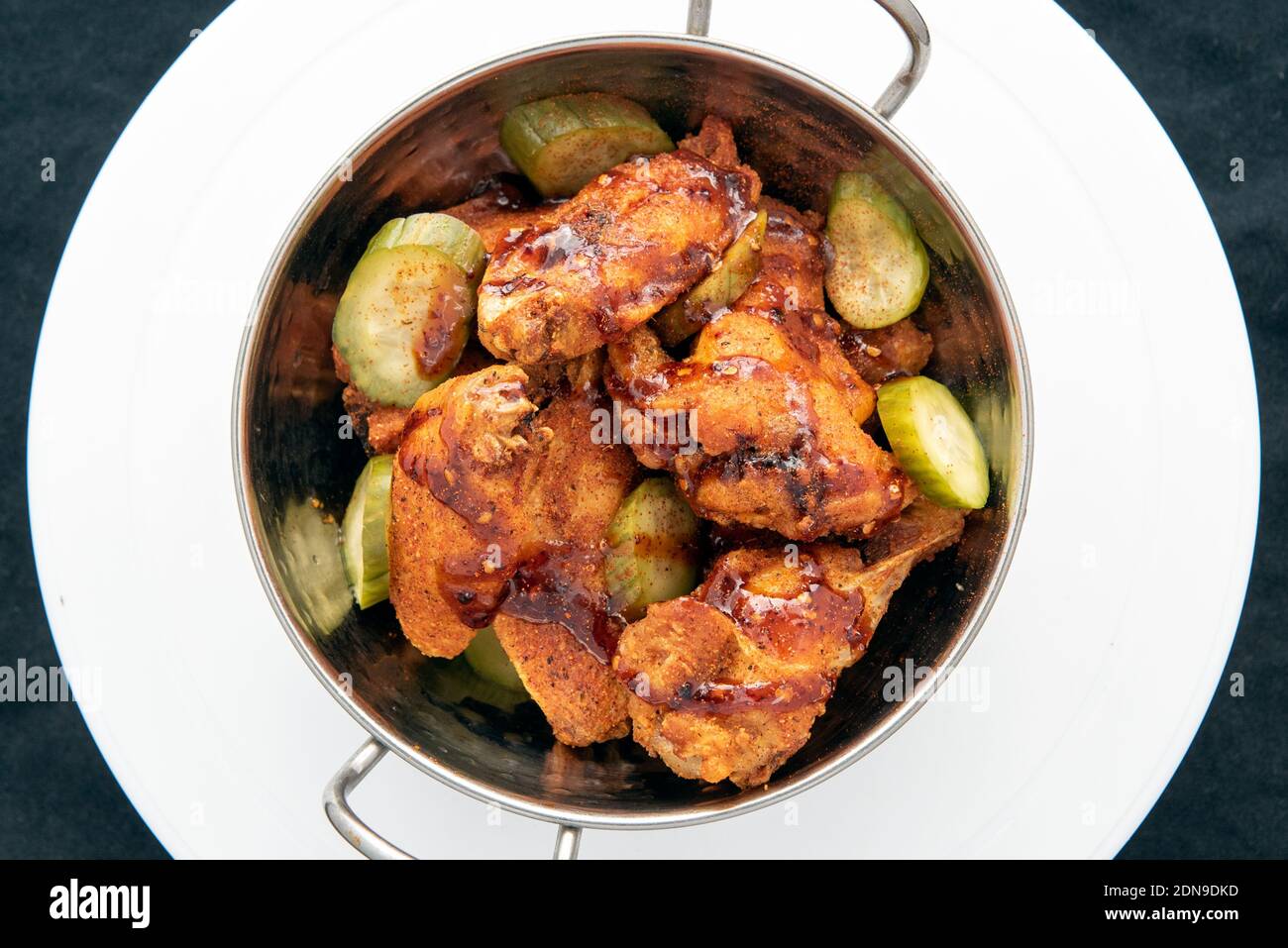 Overhead view of bowl of hot chicken wings and drumsticks for a great