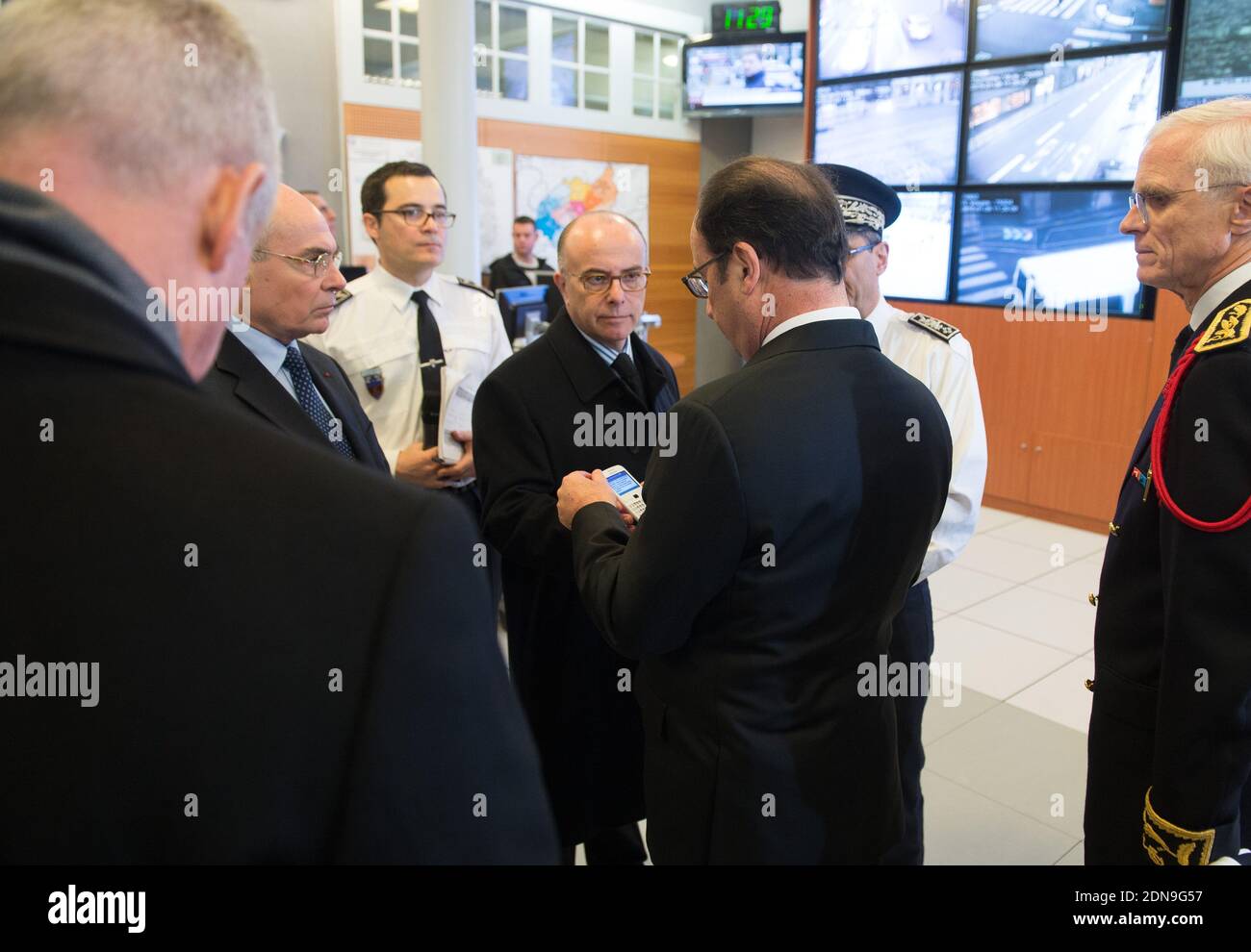 French President Francois Hollande reads a message on Interior Minister Bernard Cazeneuve's cell phone as Hollande's Cabinet Director Thierry Lataste and Paris Police Prefect Bernard Boucault look on during a visit to the Prefecture de Police following yesterday's deadly terror attack at satirical weekly Charlie Hebdo, in Paris, France on January 8, 2015. Photo Pool by Jacques Witt/ABACAPRESS.COM Stock Photo