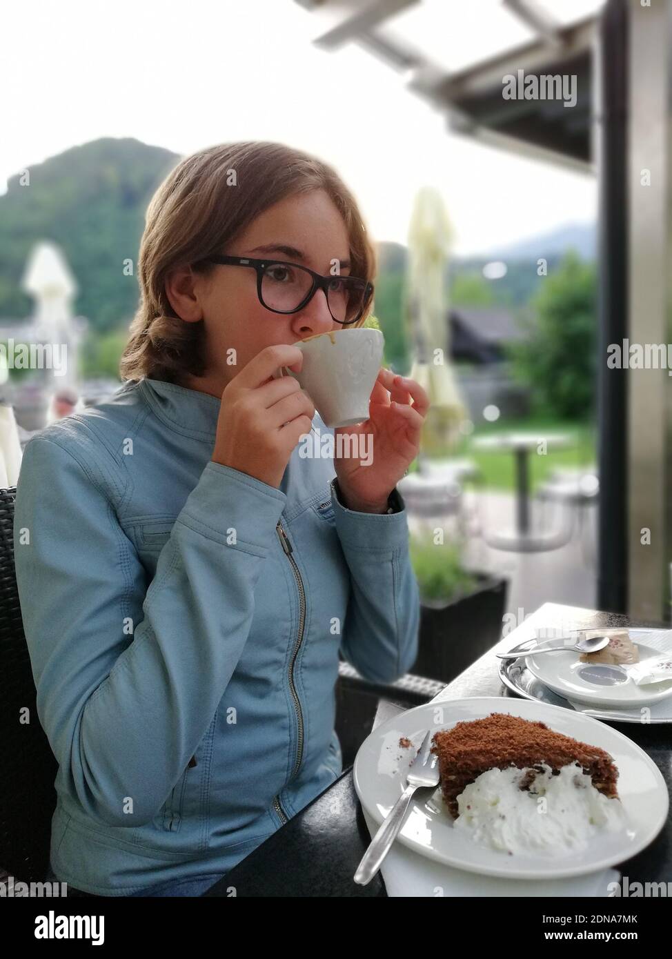 Girl Having Food And Drink At Outdoor Restaurant Stock Photo