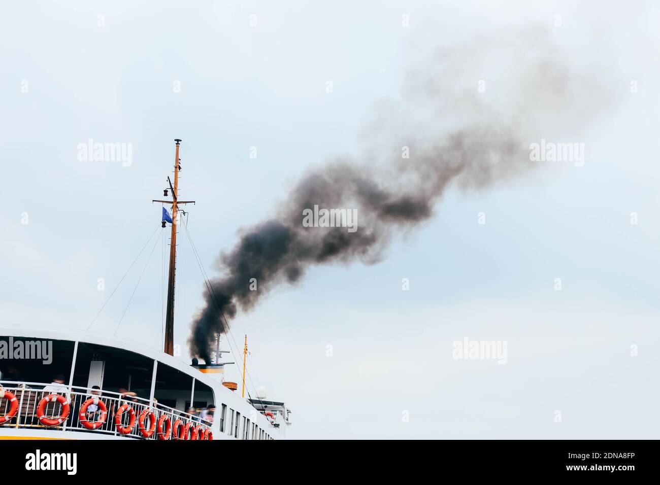 Ship polluting air with toxic smoke on blue sky background. Concept of public health problem in populated areas Stock Photo