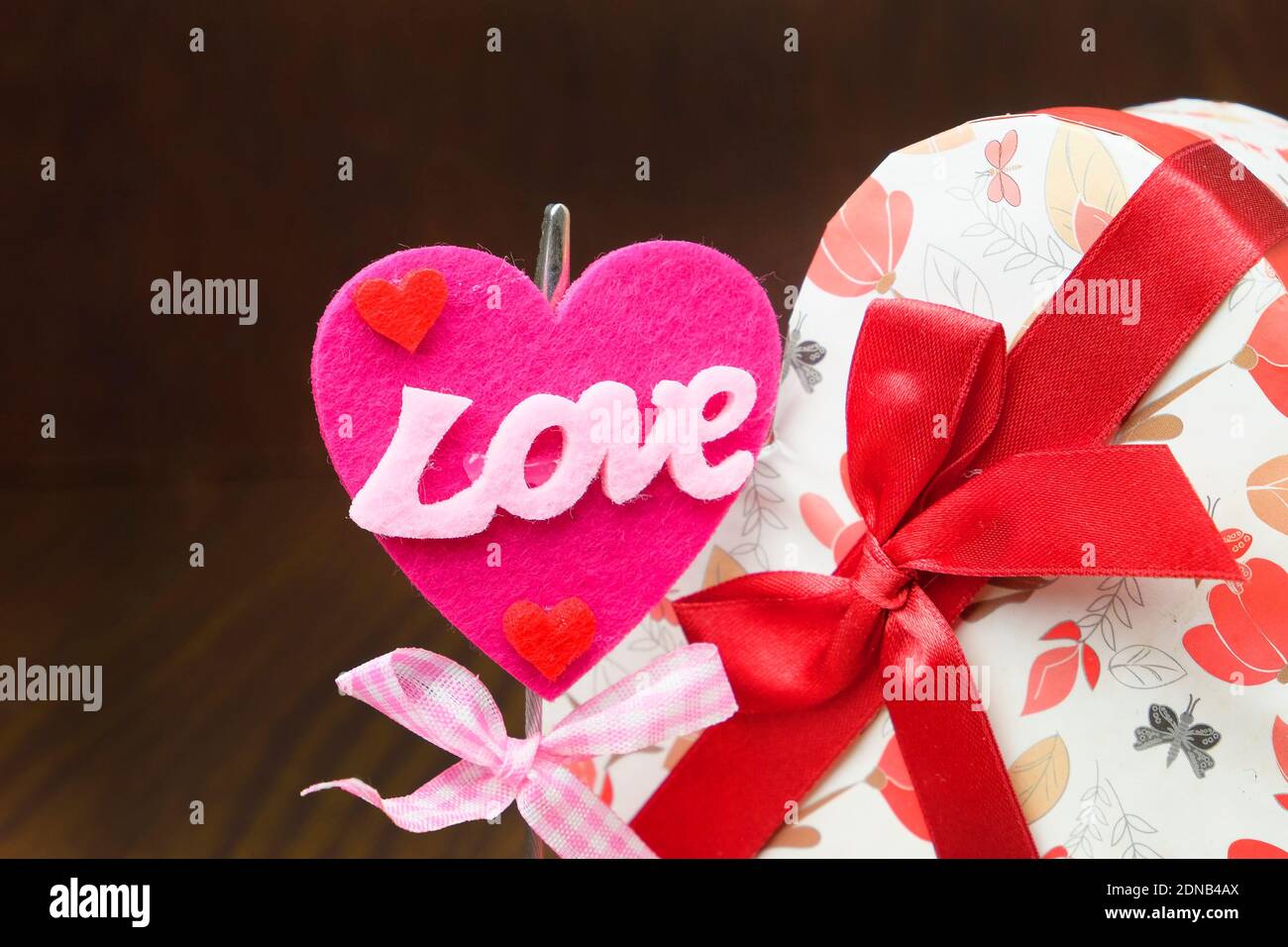 Close-up Of Love Sign And Heart Shaped Gift Box Against Wall Stock Photo -  Alamy