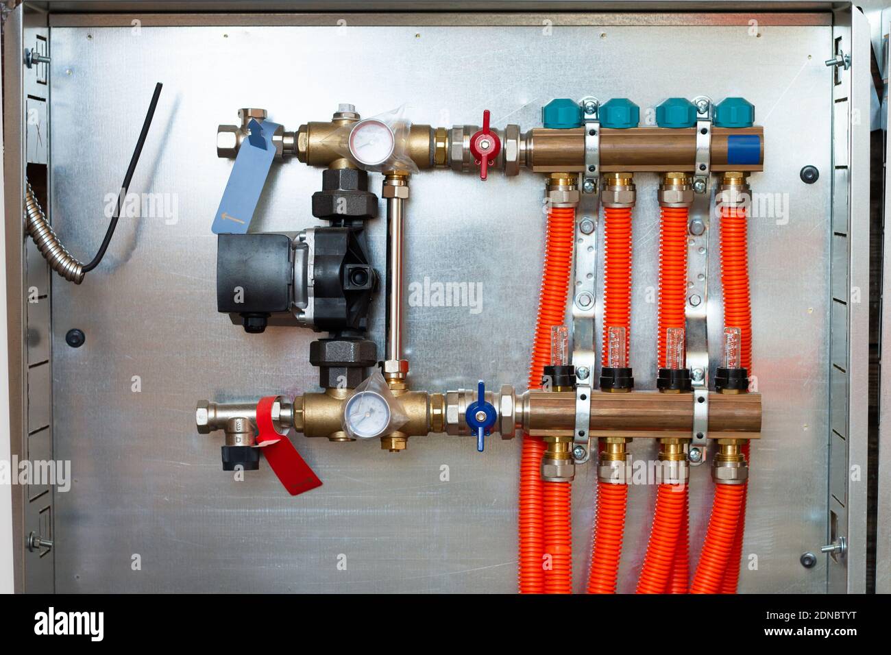 Manifold and pump group for underfloor heating with servo-motor and  flowmeter valves, installed in a private house Stock Photo - Alamy
