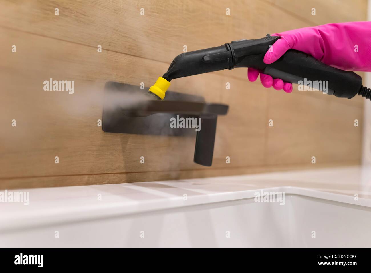 Cleaning the faucet from fungi and dirt with steam cleaner. Bathroom
