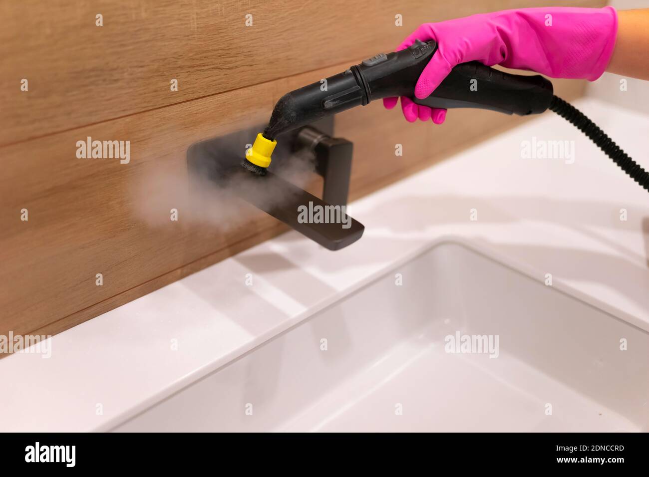 Cleaning the faucet from fungi and dirt with steam cleaner. Bathroom
