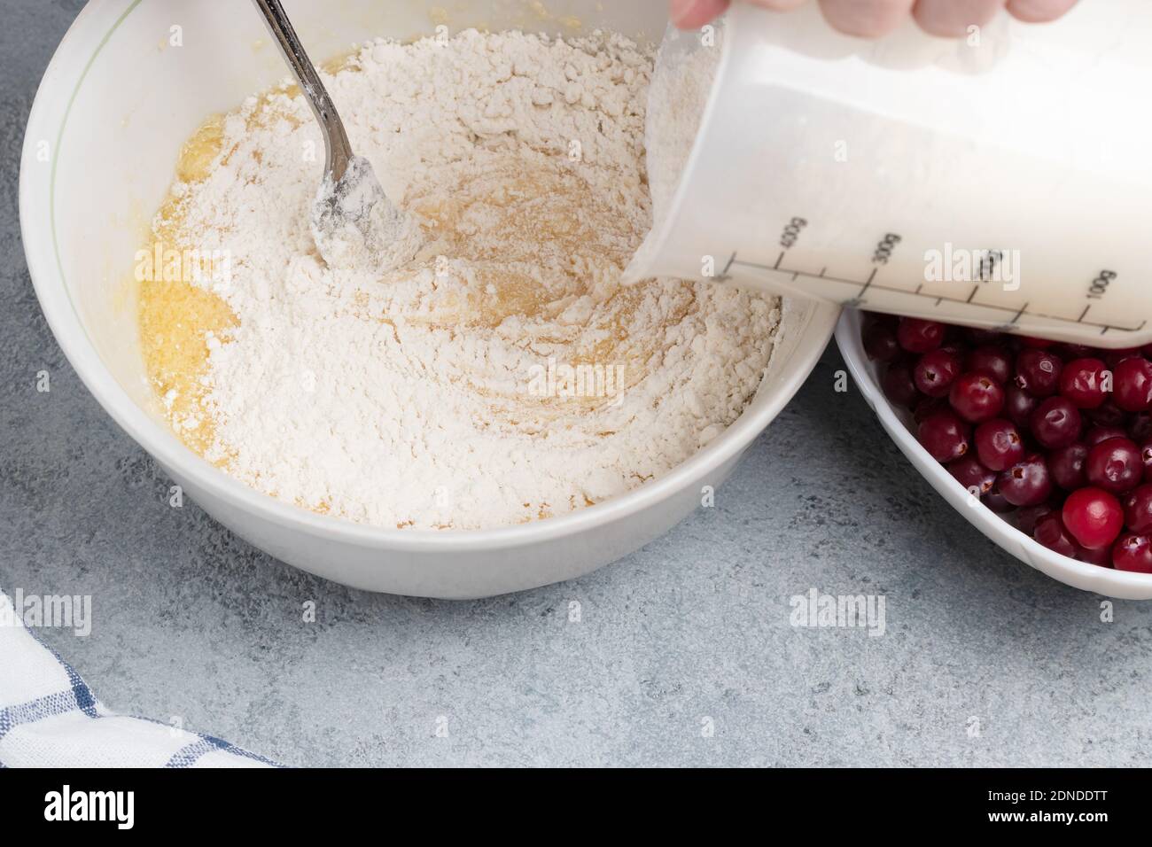 Making a dough for a sweet cranberry pie. Pouring flour Stock Photo