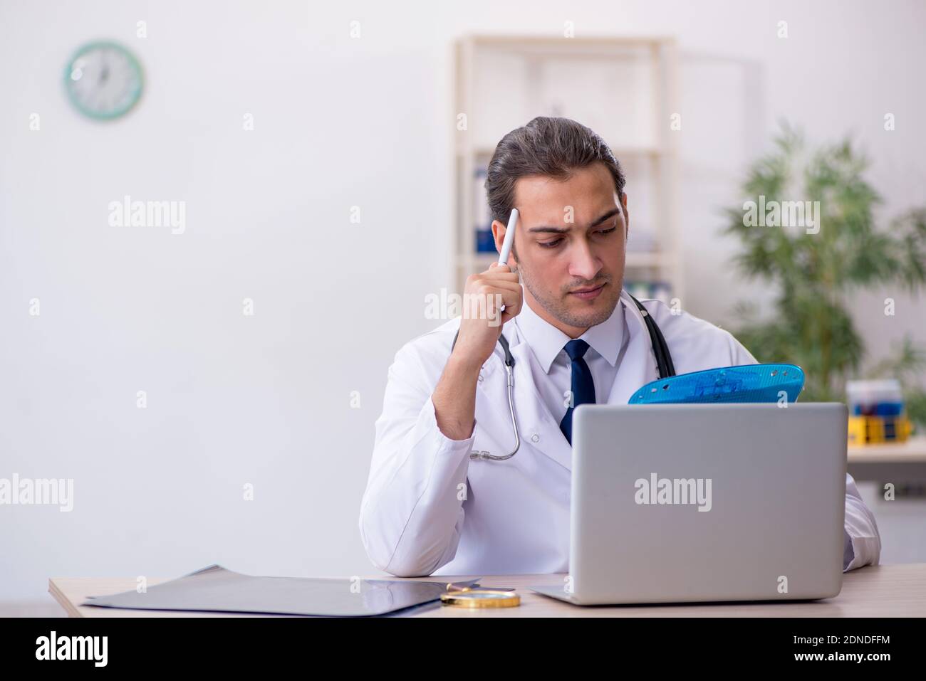 Young doctor taking notes at the hospital Stock Photo - Alamy