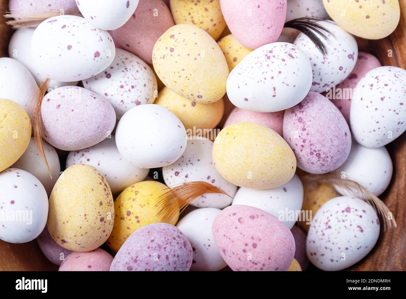 Easter holidays decoration. Easter sweets for children. Close-up. Top view. White yellow pink eggs for Easter treat. Stock Photo