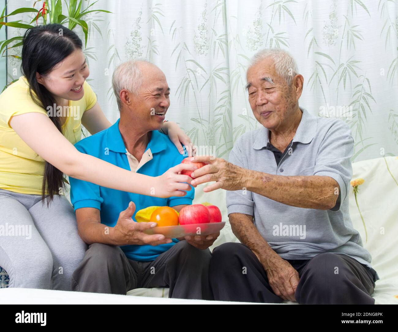 Smiling Woman Giving Fruits To Men At Home Stock Photo Alamy