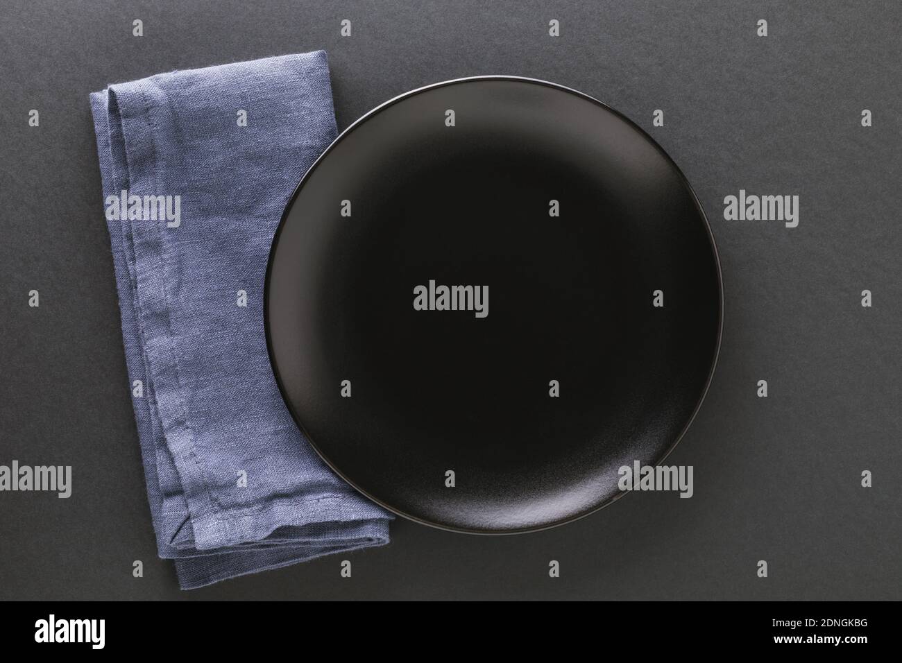 Empty black plate and napkin on a dark background. Food background. Stock Photo