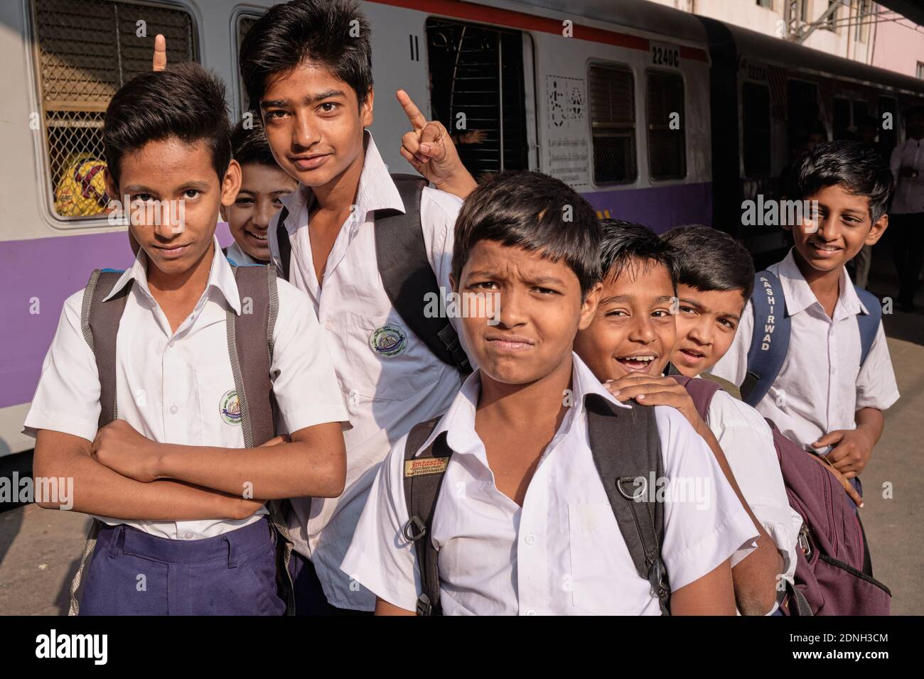 School boys on their way to school, waiting for a local train at Chhatrapati Shivaji Maharaj Terminus, the busiest railway station in Mumbai, India Stock Photo