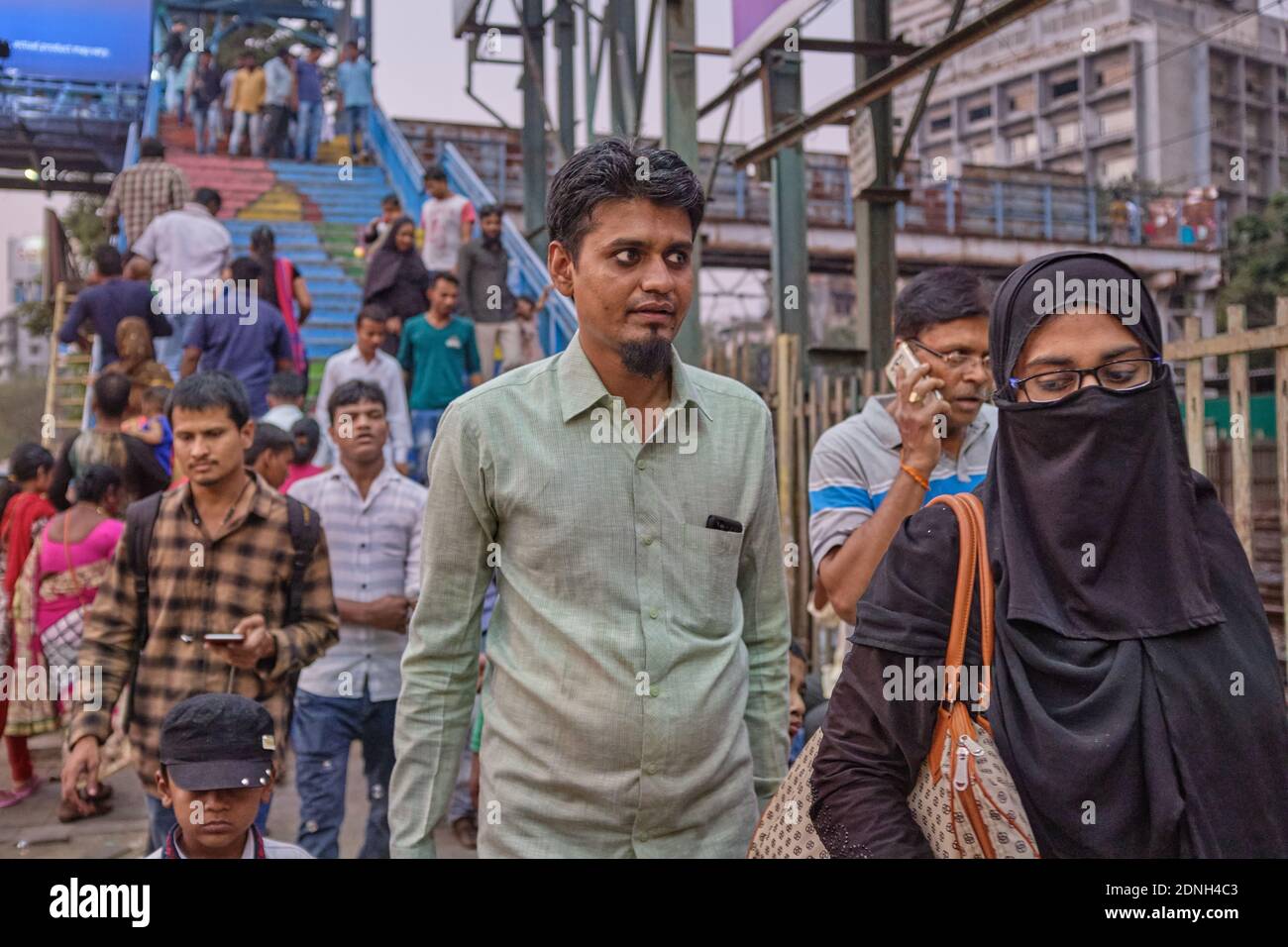 A Muslim couple outside Marine Lines railway station in Mumbai, India,  the woman's face covered with a niqab Stock Photo