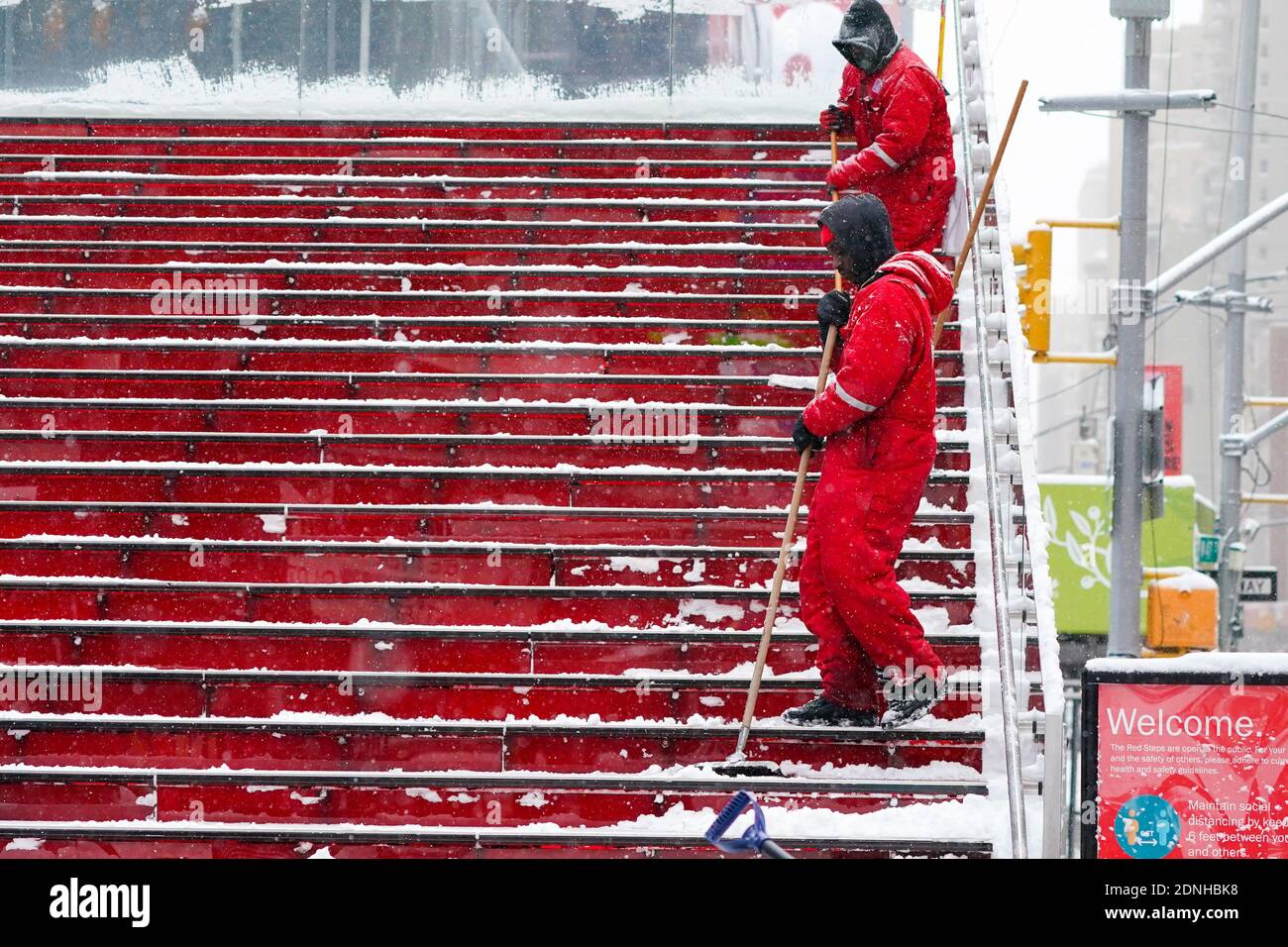 Workers clear snow at the Times Square's red steps during a winter storm.The morning after a powerful winter storm hit the US northeastern states, a major snowstorm hit the US east coast during Thursday's early hours, creating extra challenges in the midst of a coronavirus pandemic and a mass vaccination rollout taking place across the region. The winter storm, moving over New York, Pennsylvania and other northeastern states, leaves millions facing more than a foot of snow a week before Christmas, potentially disrupting coronavirus testing and delaying holiday deliveries. It also left more tha Stock Photo