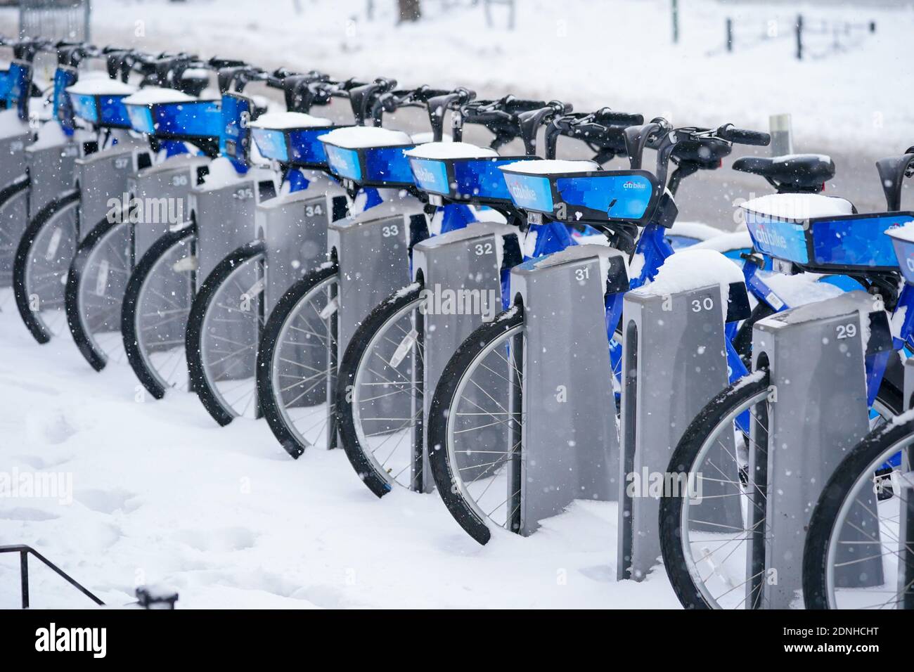 A view of CitiBikes covered with snow.The morning after a powerful winter storm hit the US northeastern states, a major snowstorm hit the US east coast during Thursday's early hours, creating extra challenges in the midst of a coronavirus pandemic and a mass vaccination rollout taking place across the region. The winter storm, moving over New York, Pennsylvania and other northeastern states, leaves millions facing more than a foot of snow a week before Christmas, potentially disrupting coronavirus testing and delaying holiday deliveries. It also left more than 60 million people under bad weath Stock Photo