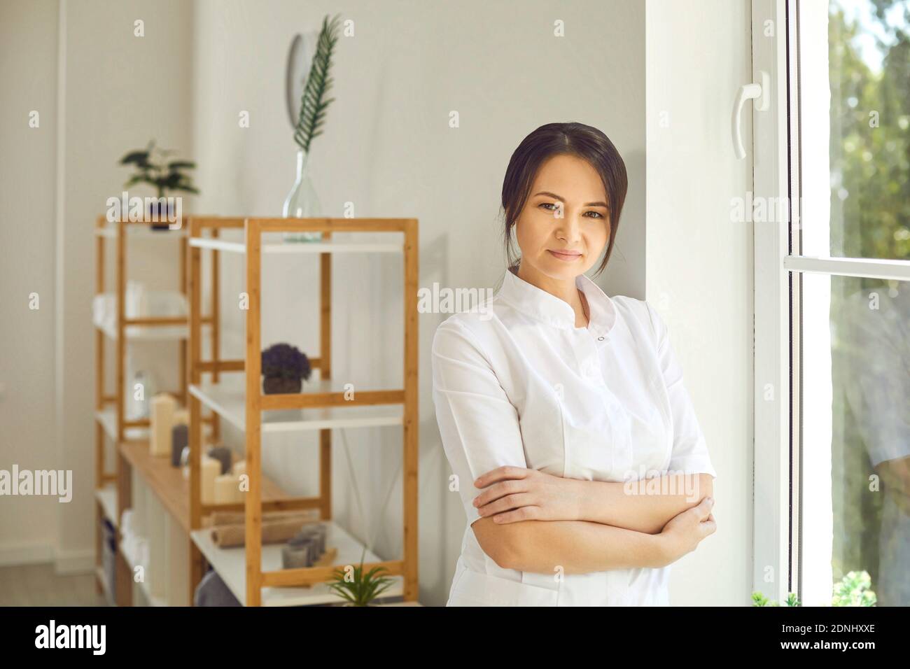 Serious professional beautician standing in her beauty salon and looking at camera Stock Photo