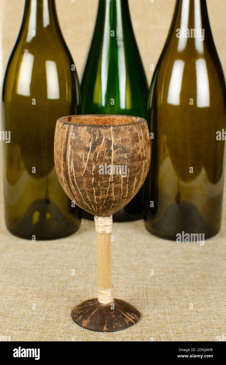 Coconut Shell  wine glass with three wine bottles not in Focus Stock Photo