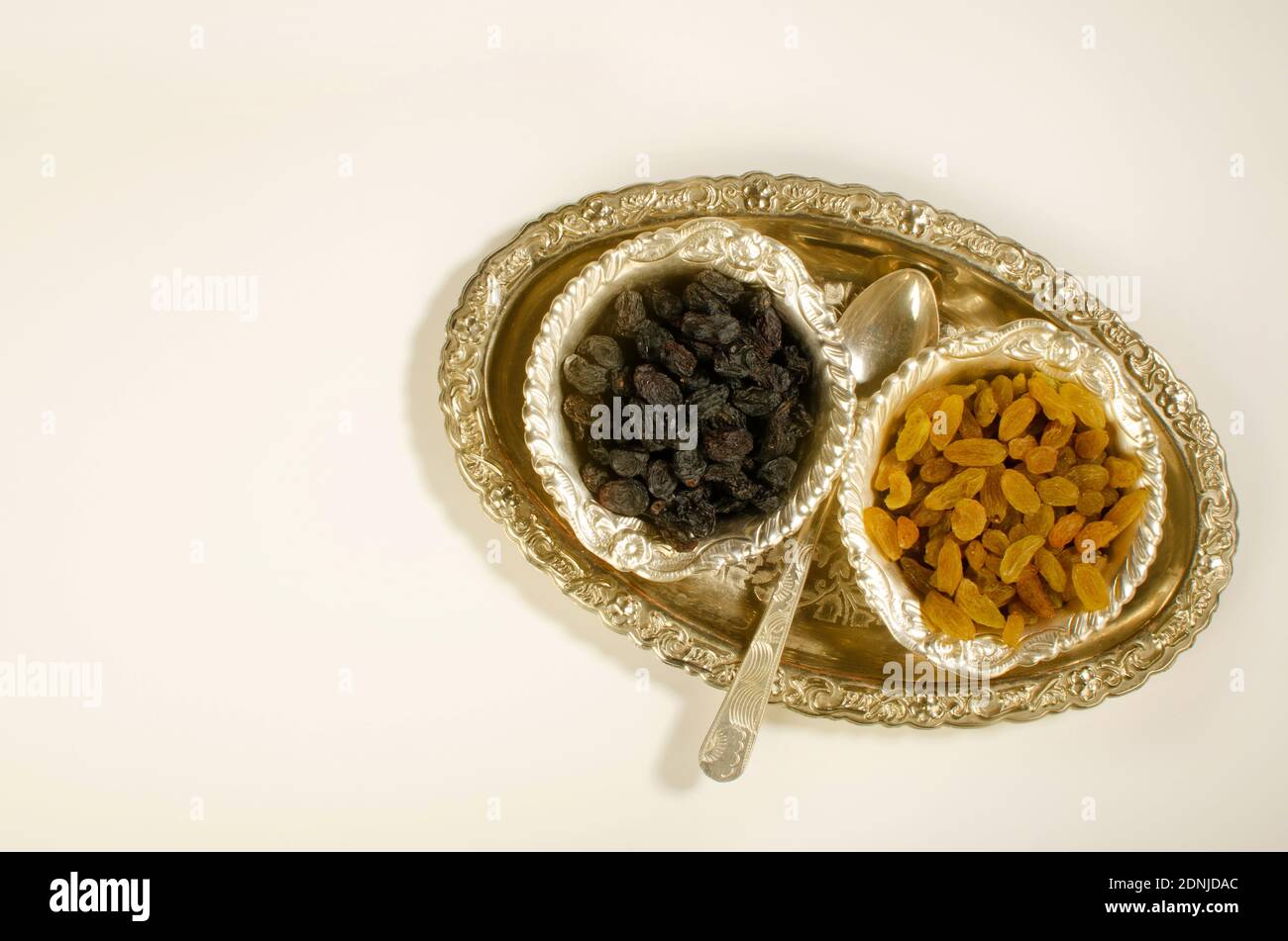 Dried Fruit Kismis or raisins presented in silver bowls. Top angle. Studio Shot Stock Photo