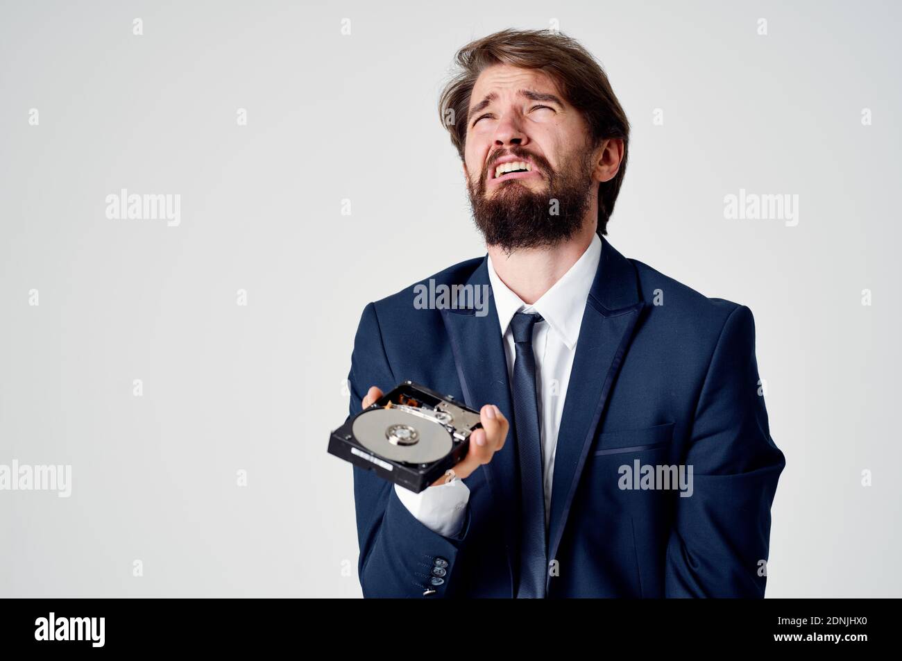 aggressive man with hard drive in hands emotions irritability light background business finance Stock Photo