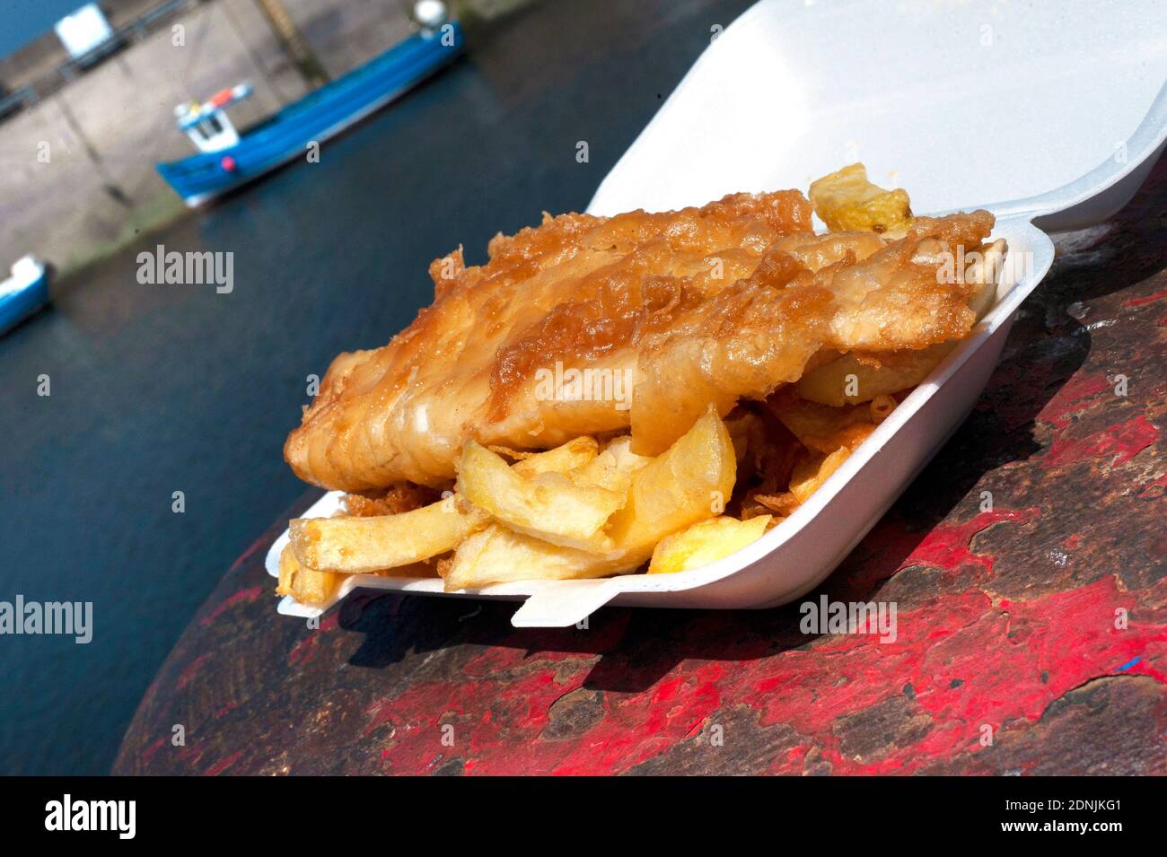 Fish and Chips on Seahouses harbour wall Stock Photo