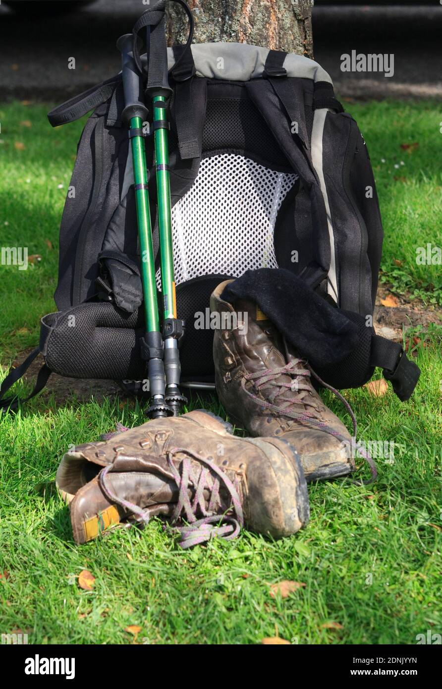 Backpack leaning against tree with hiking poles, hiking boots and socks ...