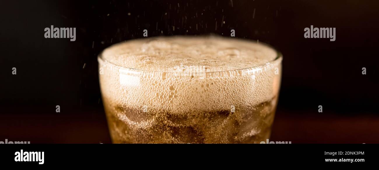 Close up panoramic banner image of cold sparking cola sodar soft drink in the glass with foam bubble Stock Photo