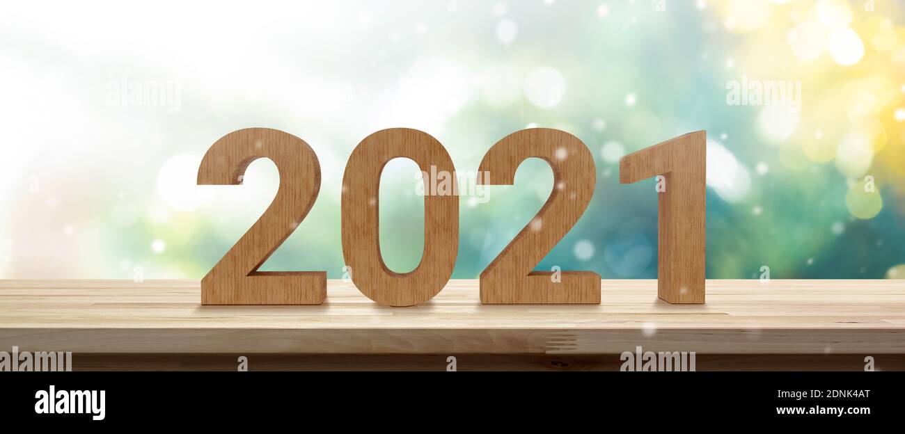 2021 numbers on wood table top in green and gold shinny banner background Stock Photo
