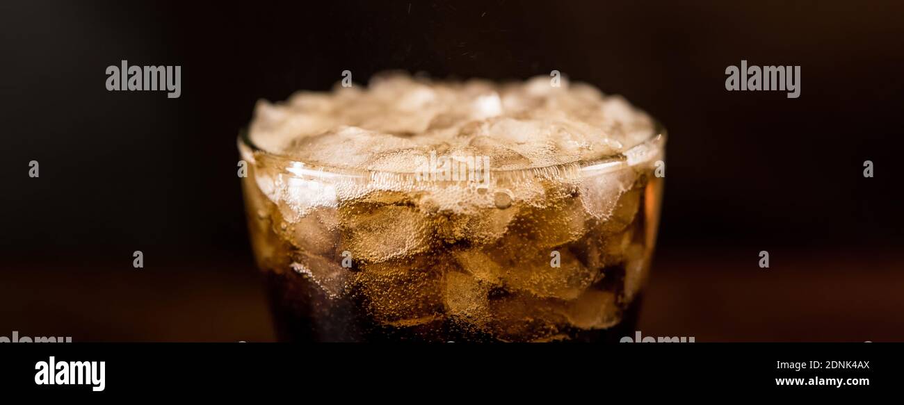 Close up panoramic banner image of cold sparking cola sodar soft drink in the glass with foam bubble Stock Photo