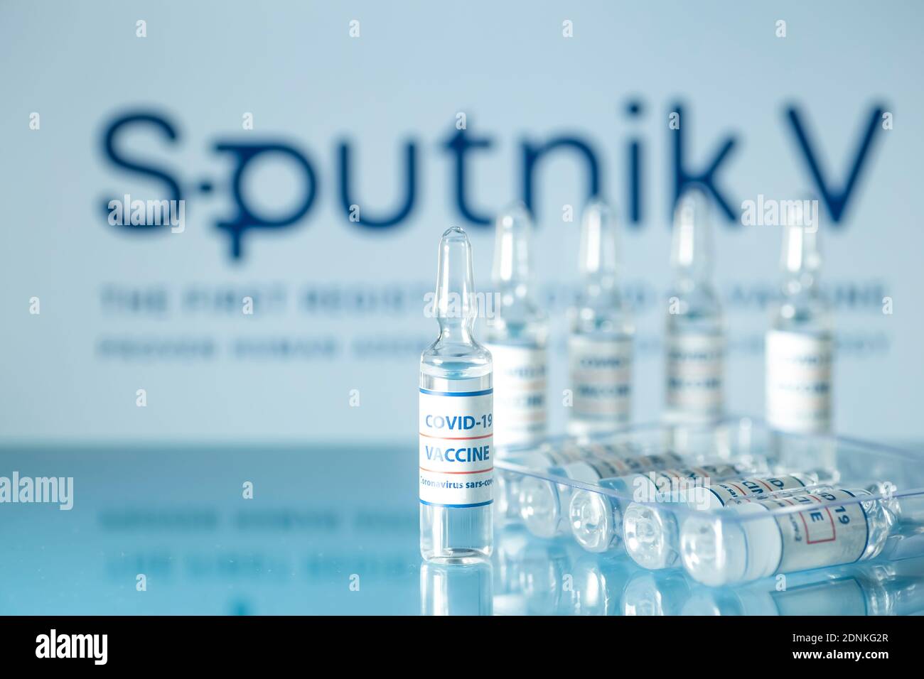 Sputnik 5 vaccine against COVID-19. Glass medical vials with liquid on the background Sputnik V company logo. Ampoules with coronavirus vaccine on a m Stock Photo