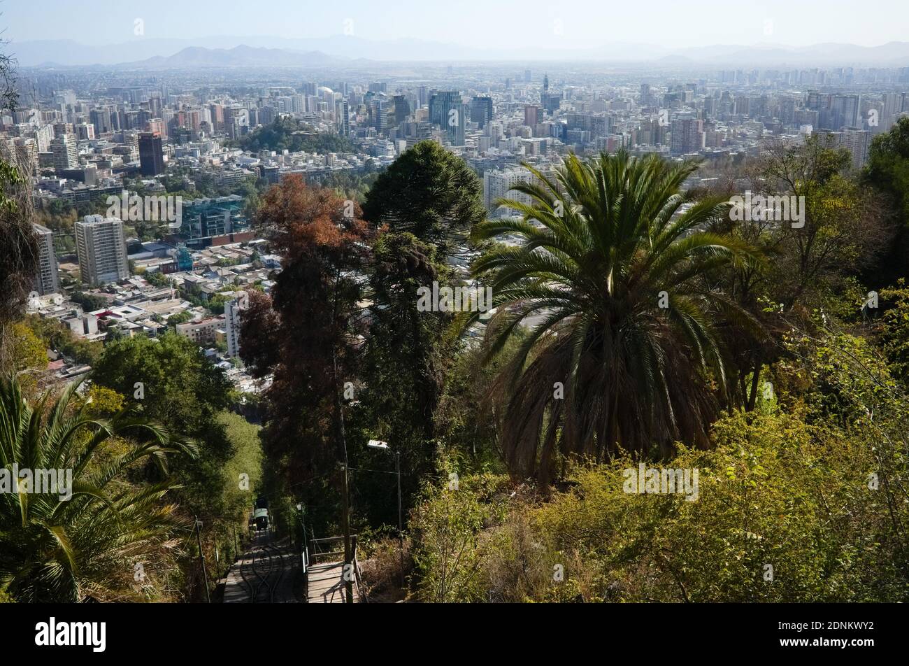 Santiago de Chile panoramic city view from San Cristobal hill with lush foliage with palm trees and funicular road. Santiago, Chile Stock Photo