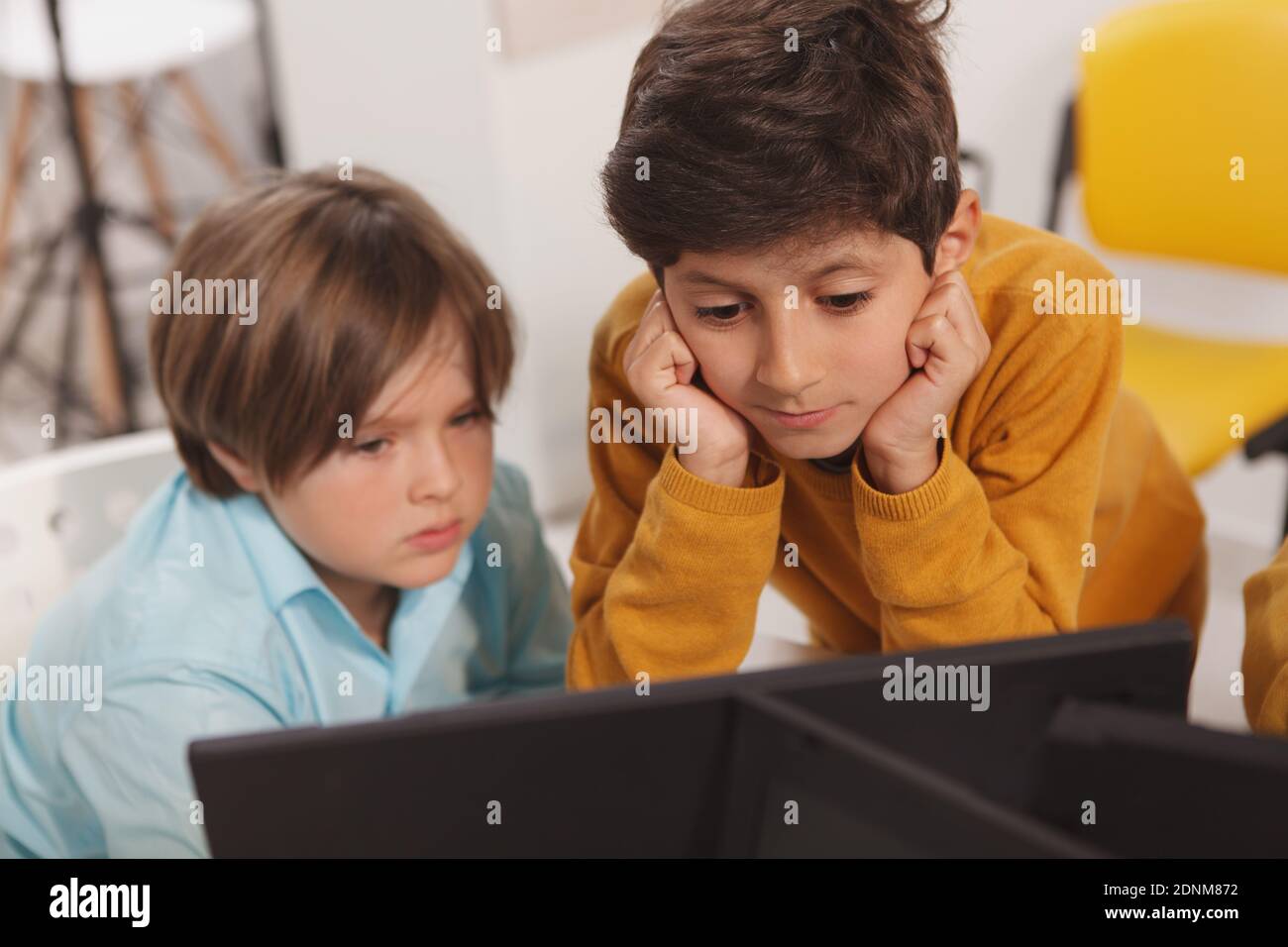 Two little schoolboys working together on a computer at school Stock ...