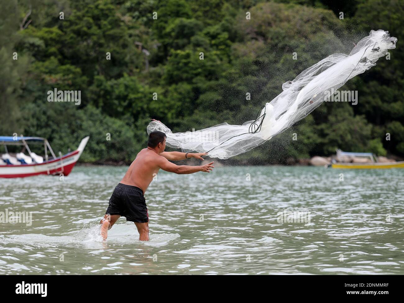 Fisher man throwing fishing net for catching fish for food Stock Photo -  Alamy