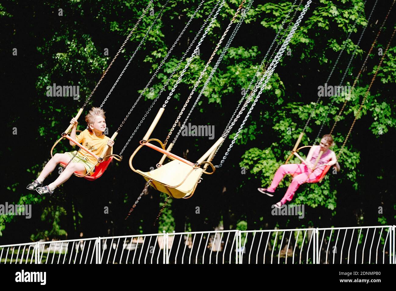 Kids Sitting On Chain Swing Ride At Amusement Park Stock Photo Alamy