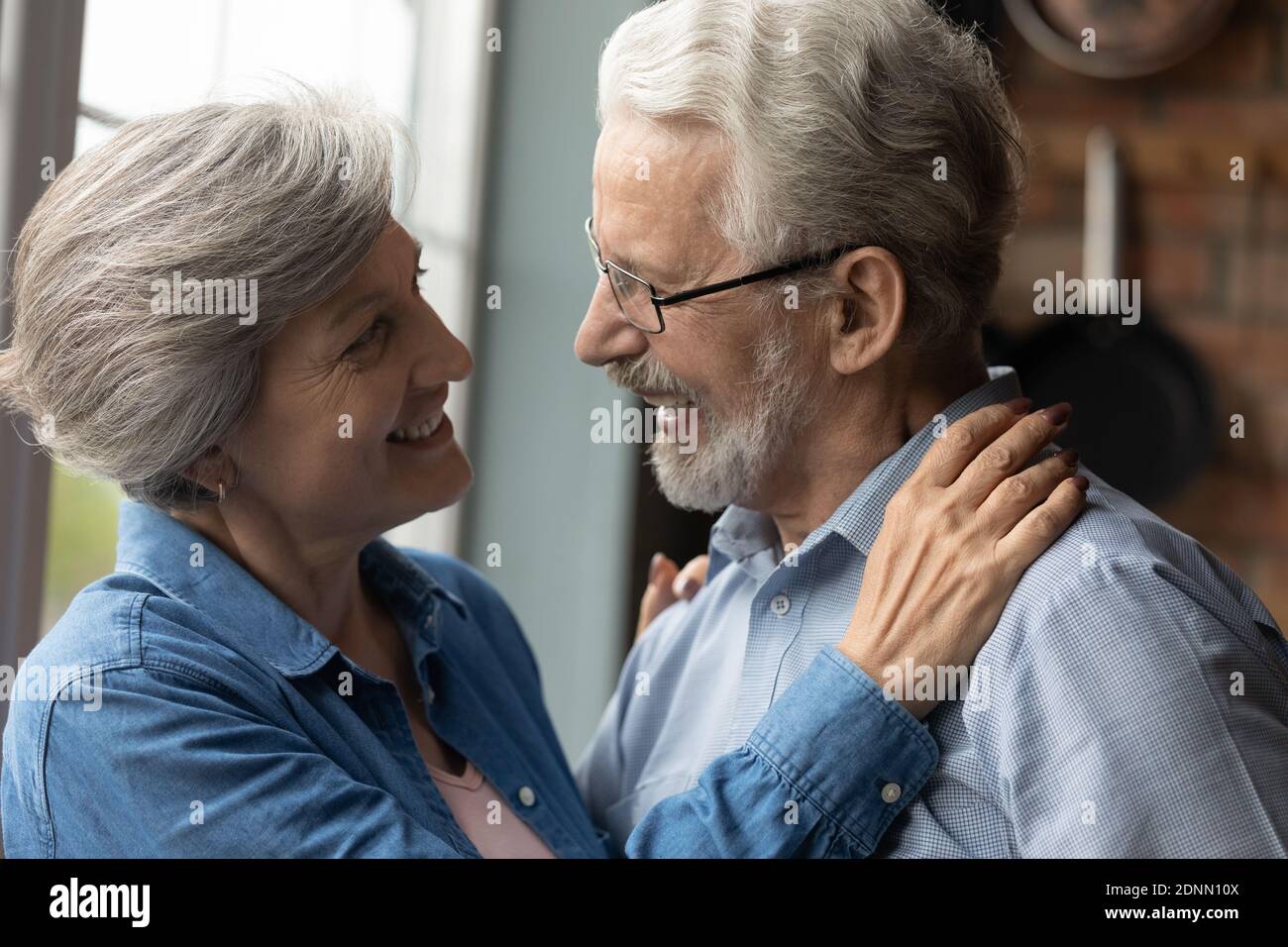 Sincere middle aged woman looking into eyes of old husband. Stock Photo